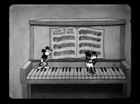 Mickey And Minnie Mouse Playing The Piano In Front Of An Open Book With