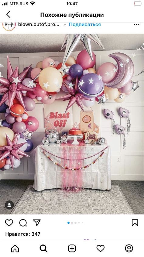 A Table Topped With Lots Of Balloons Next To A Wall Covered In Stars