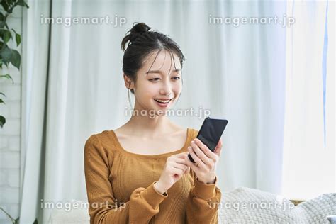 スマートフォンを操作するルームウェアを着た若い日本人女性 （人物）の写真素材 241017141 イメージマート