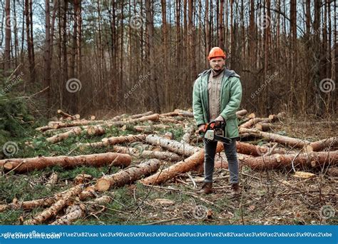 Logging Worker In A Protective Suit With A Chainsaw Cutting Down Trees Forest Destruction