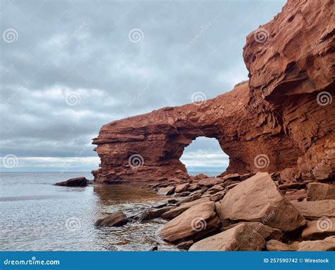 Red Sandstone Sea Cliffs Under An Overcast Sky At Cavendish Beach