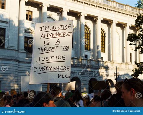 Protester Holding A Sign With A Quote About Injustice Outside Of The