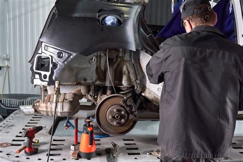 Servicio de reparación trabajador reparar coche dañado trabajando con