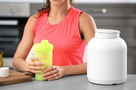 Premium Photo Young Woman Holding Bottle With Protein Shake Indoors