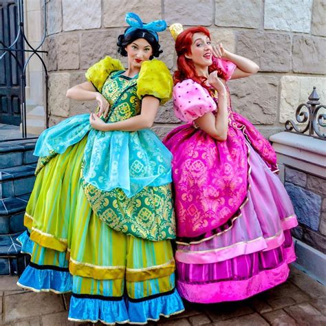 two women dressed in colorful dresses standing next to each other