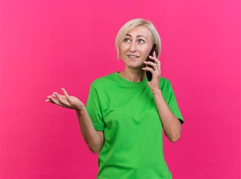 Heureux femme blonde d âge moyen slave parlant au téléphone montrant la