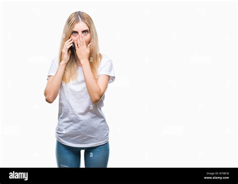 Junge hübsche blonde Frau sprechen mit Smartphone über isolierte Hintergrund decken den Mund mit