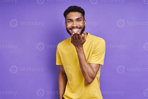 Handsome African Man Blowing A Kiss And Smiling While Standing Against