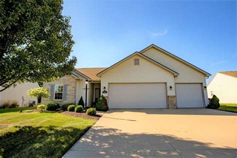 a large house with two garages in the front yard