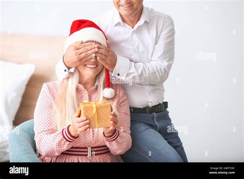 Mature Husband Giving His Wife Christmas Present At Home Stock Photo Alamy