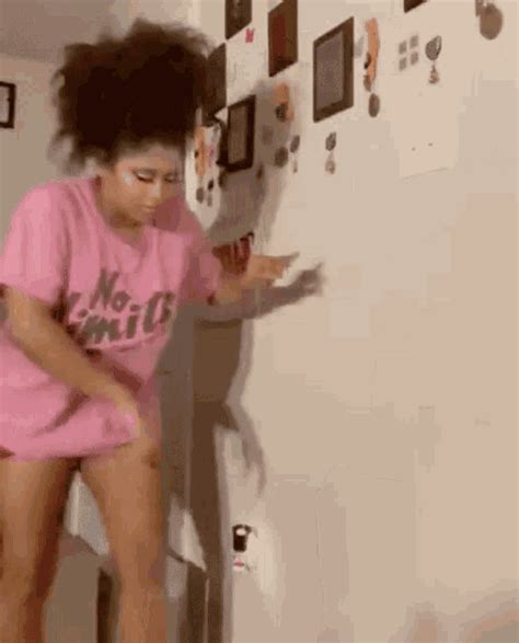 A Woman In Pink Shirt And Shorts Standing Next To Refrigerator With Magnets On The Wall