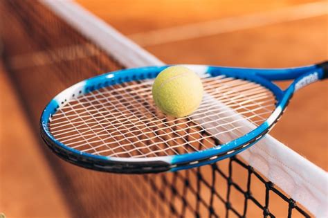 Raqueta De Tenis Con Una Pelota En La Red De Tenis Foto Premium