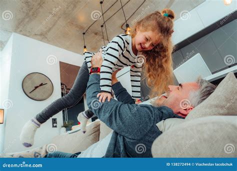 Cute Small Daughter in a Striped Sweater Feeling Contented Stock Photo ...