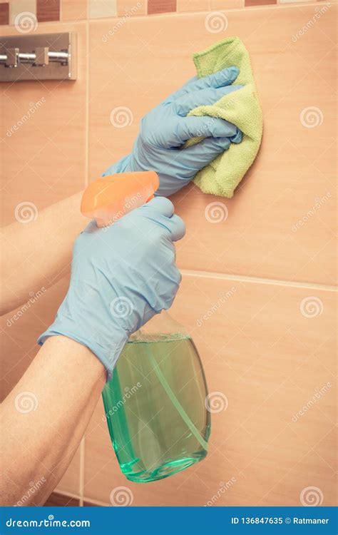 Hand Of Senior Woman Wiping Bathroom Tiles Using Microfiber Cloth With Detergent Household