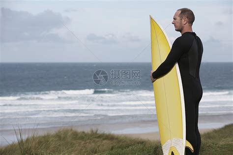 男性冲浪者在海滩上携带冲浪板的侧面观视海景高清图片下载 正版图片321865069 摄图网