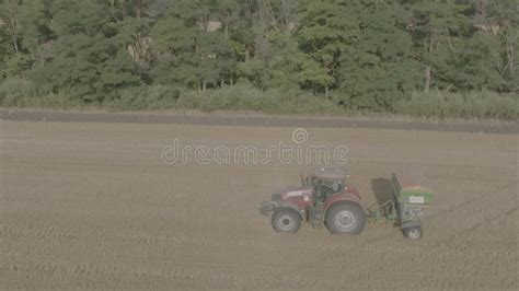 Farmer On Tractor Fertilizing Agricultural Field Spreading Mineral