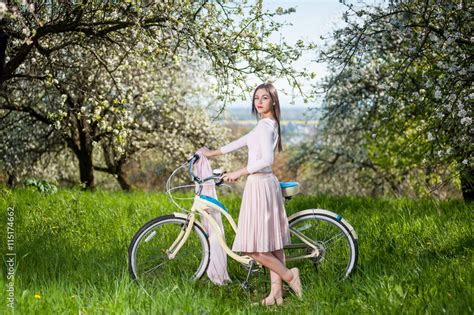 Brunette Woman With Long Hair Wearing Nice White Dress Keeps Bicycle