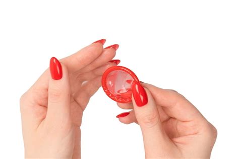 Premium Photo A Red Condom In A Woman Hand With Red Nails Isolated On