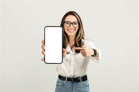 Premium Photo Engaging Young Woman Showcasing A Smartphone With A