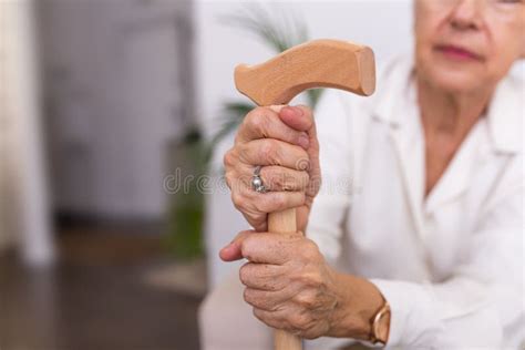 Hands Of An Old Woman With A Cane Elder Lady Sitting On The Couch With Wooden Walking Stick