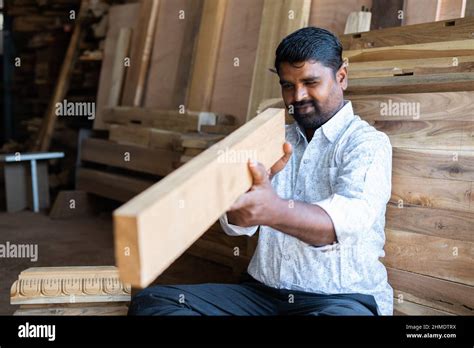 Focus On Carpenter Carpenter Checking Straightness Of Wood At