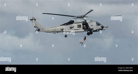 Sailors demonstrate rescue swimmer operations from an MH-60R Sea Hawk ...