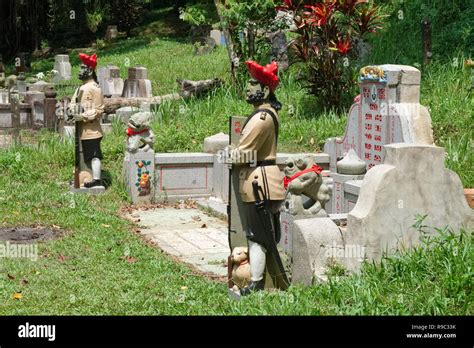 Figures of Sikh soldiers stand guard at a Chinese grave in Bukit Brown ...