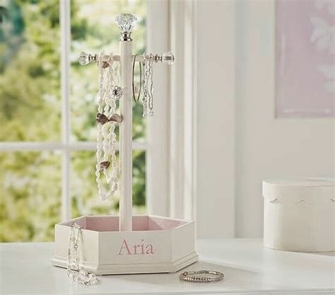 A White Table With A Jewelry Box And Ring Holder On It In Front Of A