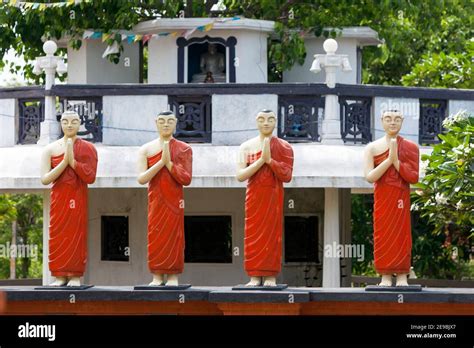 A Row Of Praying Buddhist Monk Statues Stand In Front Of The Bodhi Tree