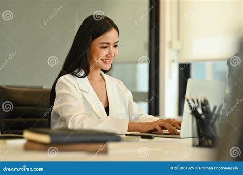 Successful Businesswoman In Trendy Suit Working On Laptop Computer At