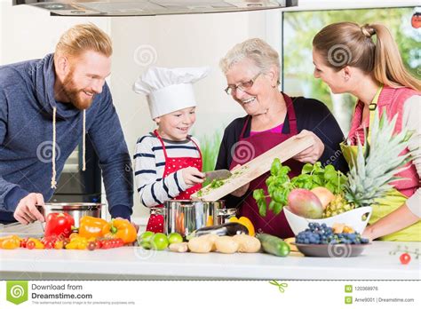 Familia Que Cocina En Hogar Multigenerational Foto De Archivo Imagen