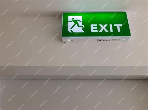 Premium Photo | The green fire exit symbol on the ceiling shows escape ...