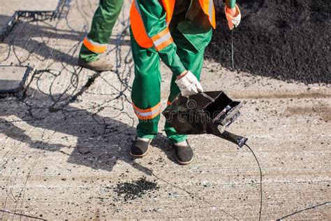 The Man Working Asphalt Pouring Tar For Road Repair Stock Photo