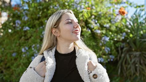 Blonde Woman Smiling In A Lush Garden Portraying Youth Beauty And Outdoor Serenity Stock