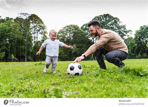 Gl Cklicher Vater Spielt Mit Seinem Sohn In Einem Park Fussball Ein