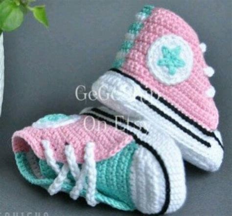 A Crocheted Pink And White Sneaker With Shamrock On The Side Sitting