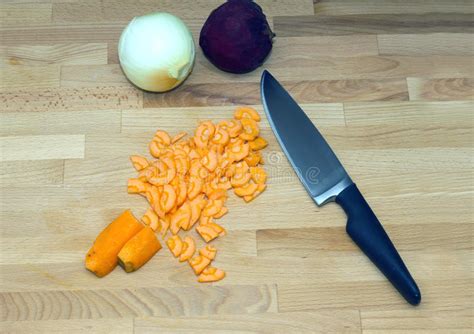 Cenouras Cortadas E Uma Grande Faca De Cozinha De Aço O Punho Preto