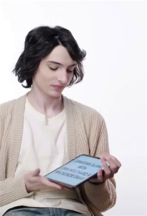 A Woman Sitting Down And Looking At An Electronic Device