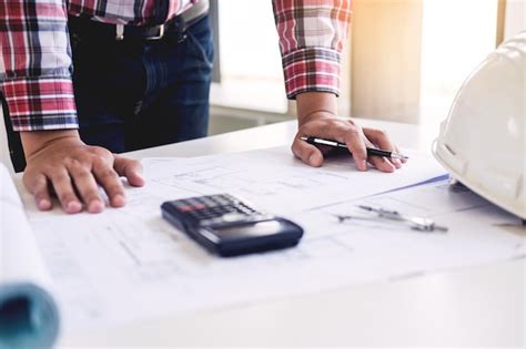 Premium Photo Midsection Of Engineer Drawing Blueprint In Office