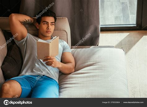 Handsome Pensive Man Reading Book While Chilling Sofa Self Isolation