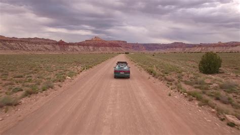 An Aerial Shot Car Drives Through Desert On Stock Footage SBV 307216425