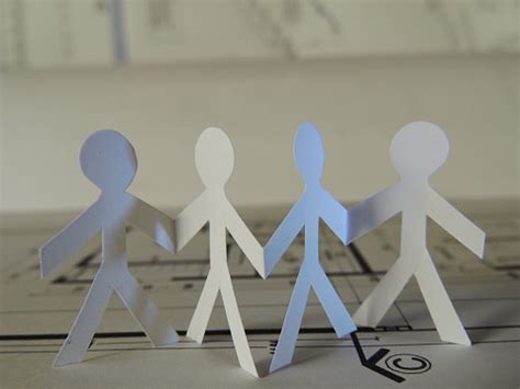 Four Silhouettes Of People Cut Out On Paper On A Plane Stock Photo