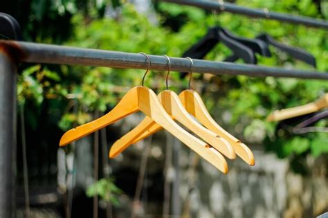 Premium Photo Wooden Clothes Hanger With A Natural Leafy Background