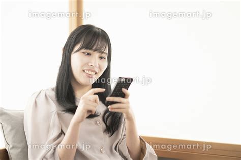 自宅でスマートフォンを操作する日本人女性 （人物）の写真素材 151981894 イメージマート