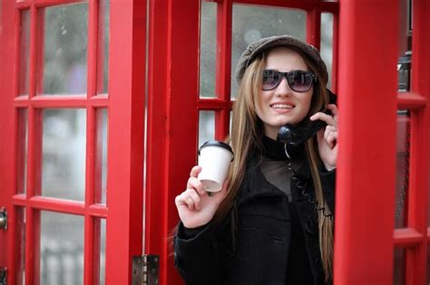 Hermosa joven en una cabina telefónica la niña está hablando por