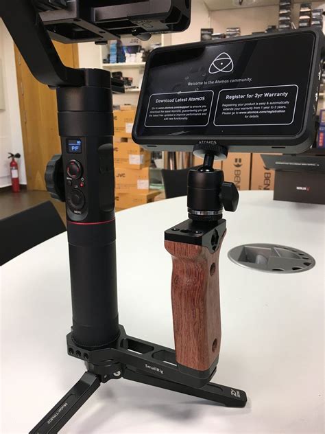 A Tripod Mounted On Top Of A Table With A Wooden Object In Front Of It