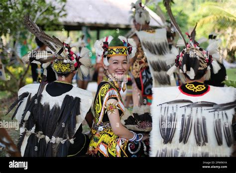 Charming Orang Ulu Lass Of Sarawak Flanked By Warriors Adorned With Feathered Traditional Attire