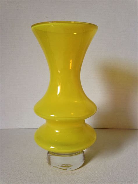 A Yellow Vase Sitting On Top Of A White Table