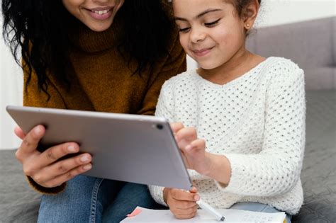 Adolescente Aidant La Petite Soeur à Laide De La Tablette Pour Lécole