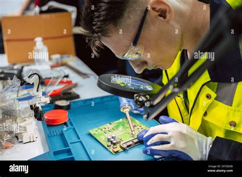 Electrician Technician Using Hot Soldering Iron To Fix Repair Small Electrical Digital Computer